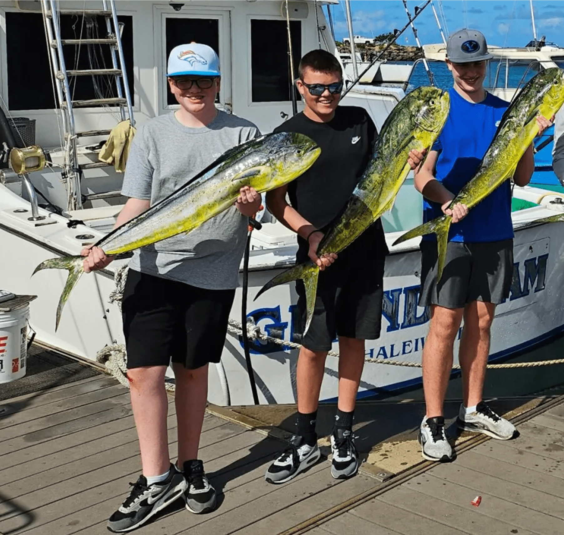 Friends displaying their fishing catch on dock