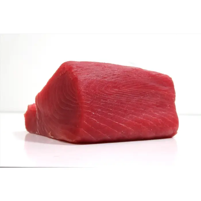 Raw tuna loin on white surface