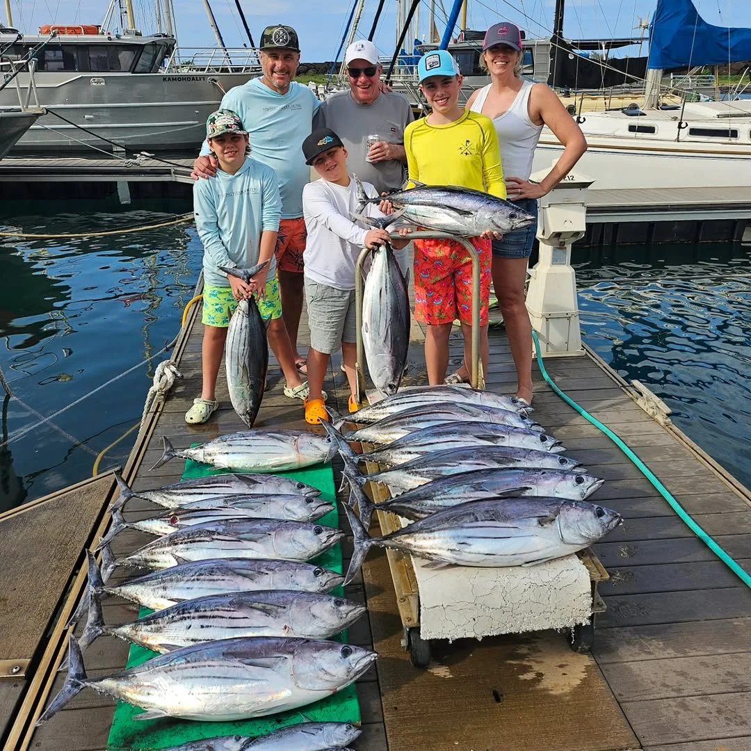 Group displaying freshly caught fish at marina