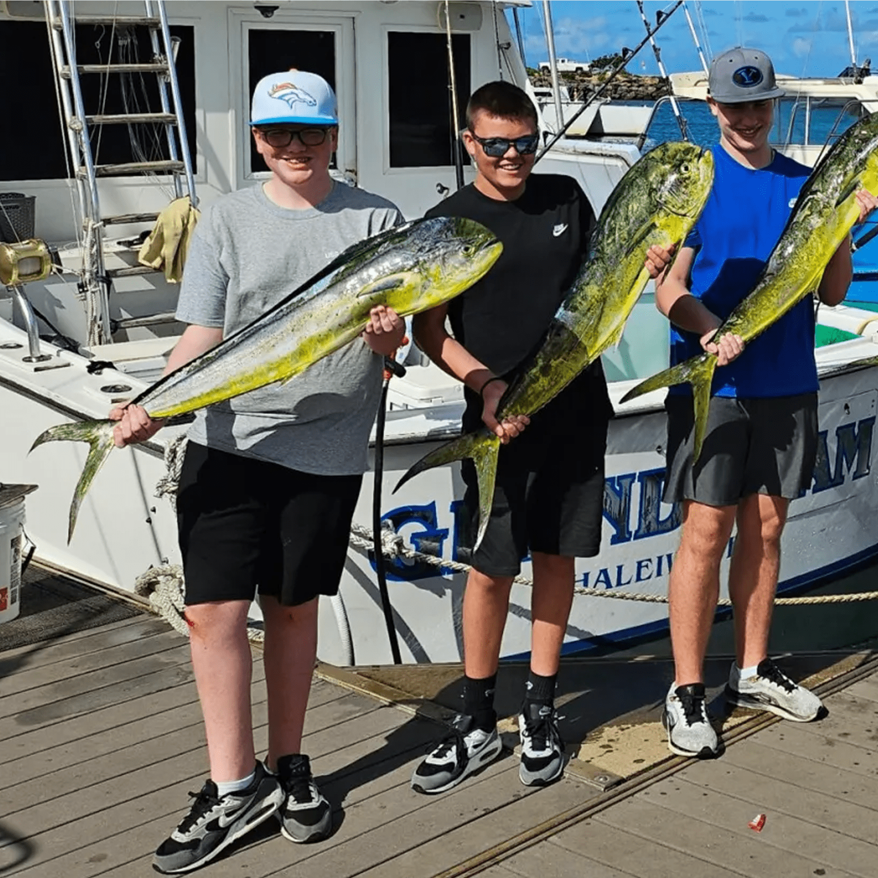 Friends displaying their fishing catch on dock